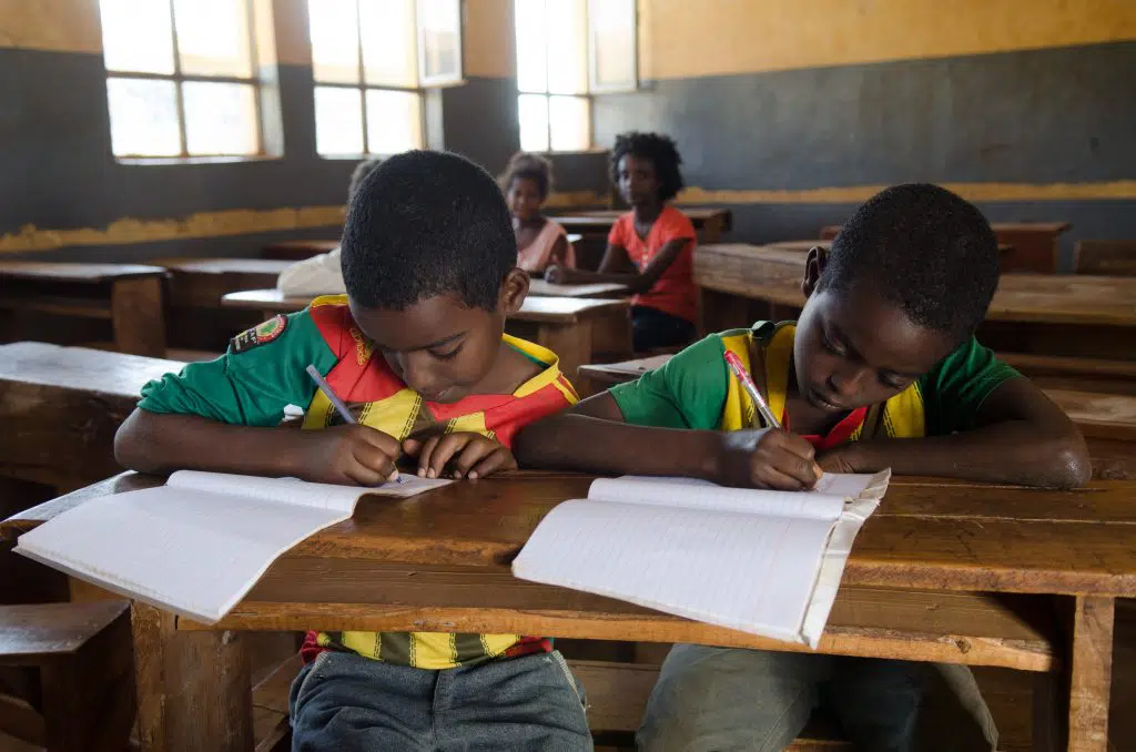 Kids studying on a desk.