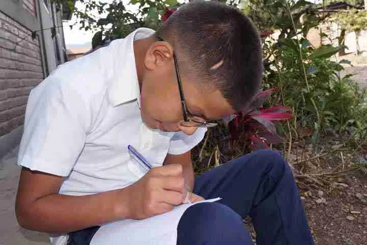Picture of Oscar writing in a book