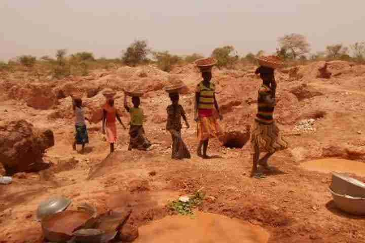 Children walking in a queue with baskets on their head
