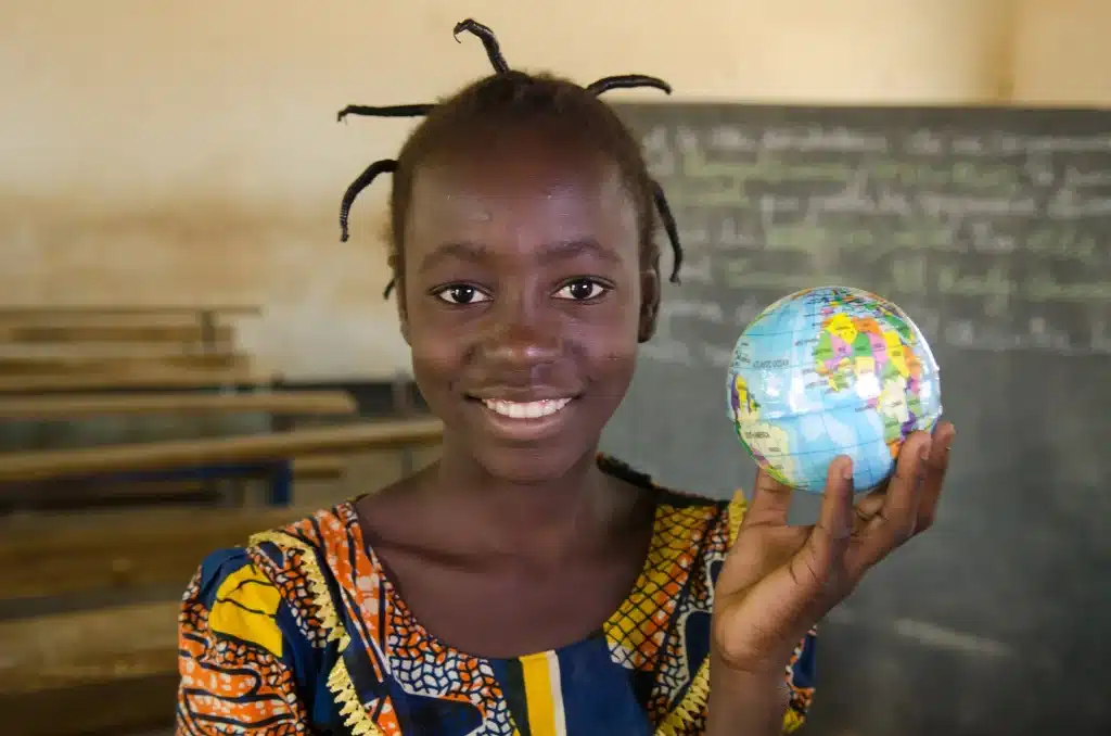 Girl with tiny global in her hand