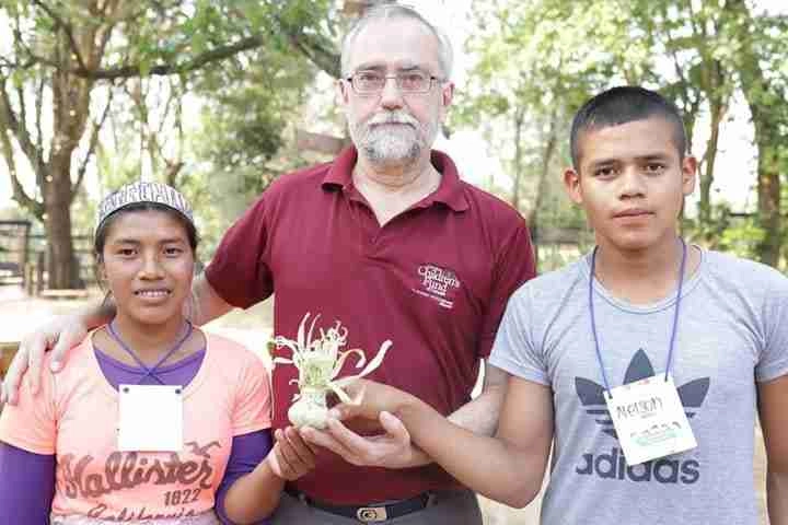 Picture of Jorge holding a plant with teenagers