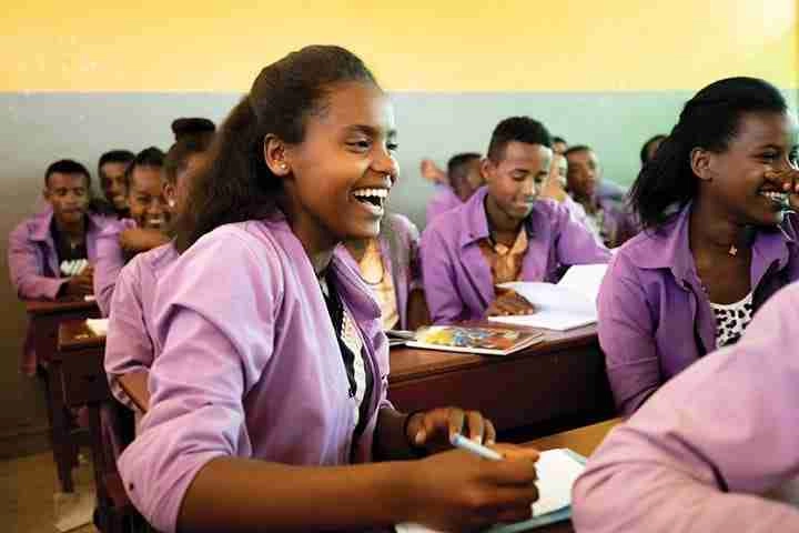 Students smiling on desk